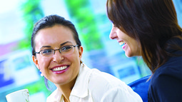 two business women having a coffee chat and laughing