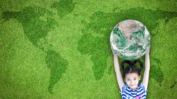 Kind mit Weltkugel vor grüner Weltkarte.jpeg