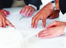 mehrere Hände auf Besprechungstisch.jpg