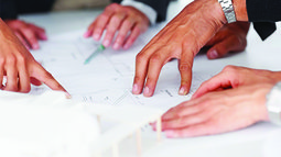 mehrere Hände auf Besprechungstisch.jpg